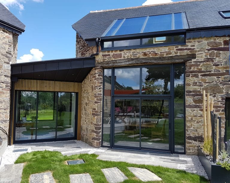Maison rénovée avec de nouvelles fenêtres en aluminium noir — solution moderne pour plus de lumière, de confort et de performance énergétique