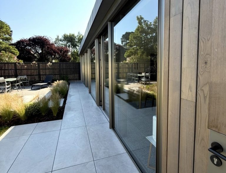 Baie vitrée coulissante en aluminium et mur avec bardage bois