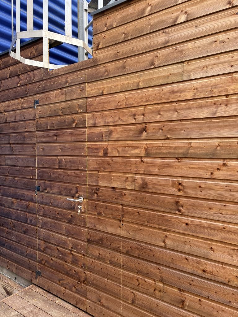 Porte incrustée dans un bardage bois